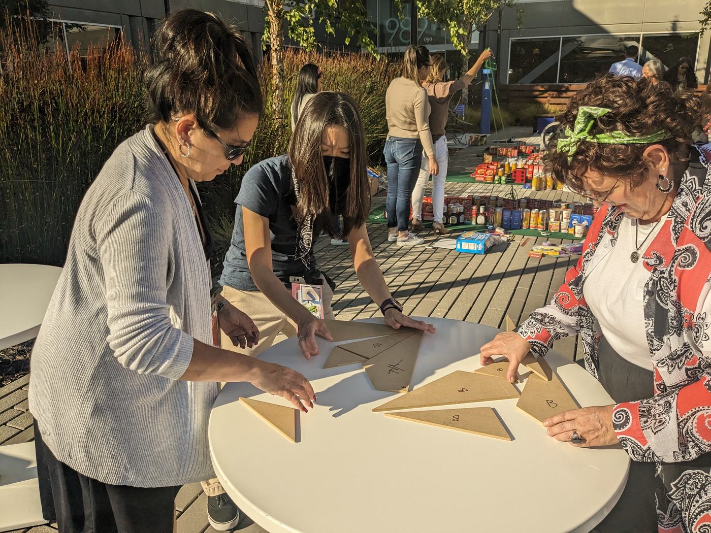 Teammates shaping cardboard for a course obstacle