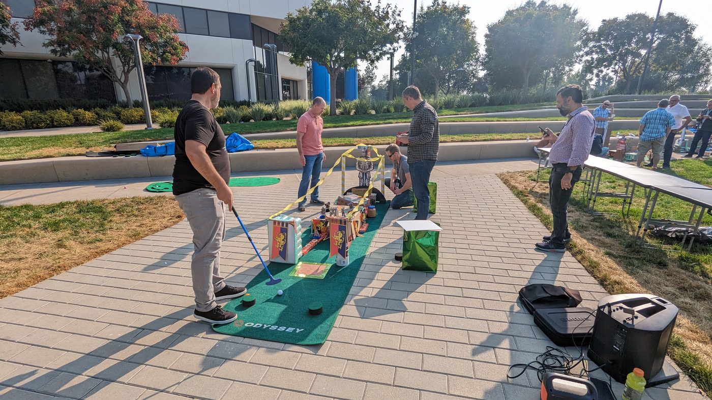 A participant lines up a putt on an outdoor green